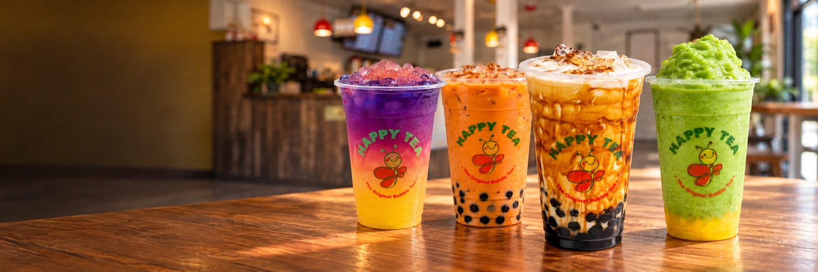 Four Happy Tea drinks lined up on the counter